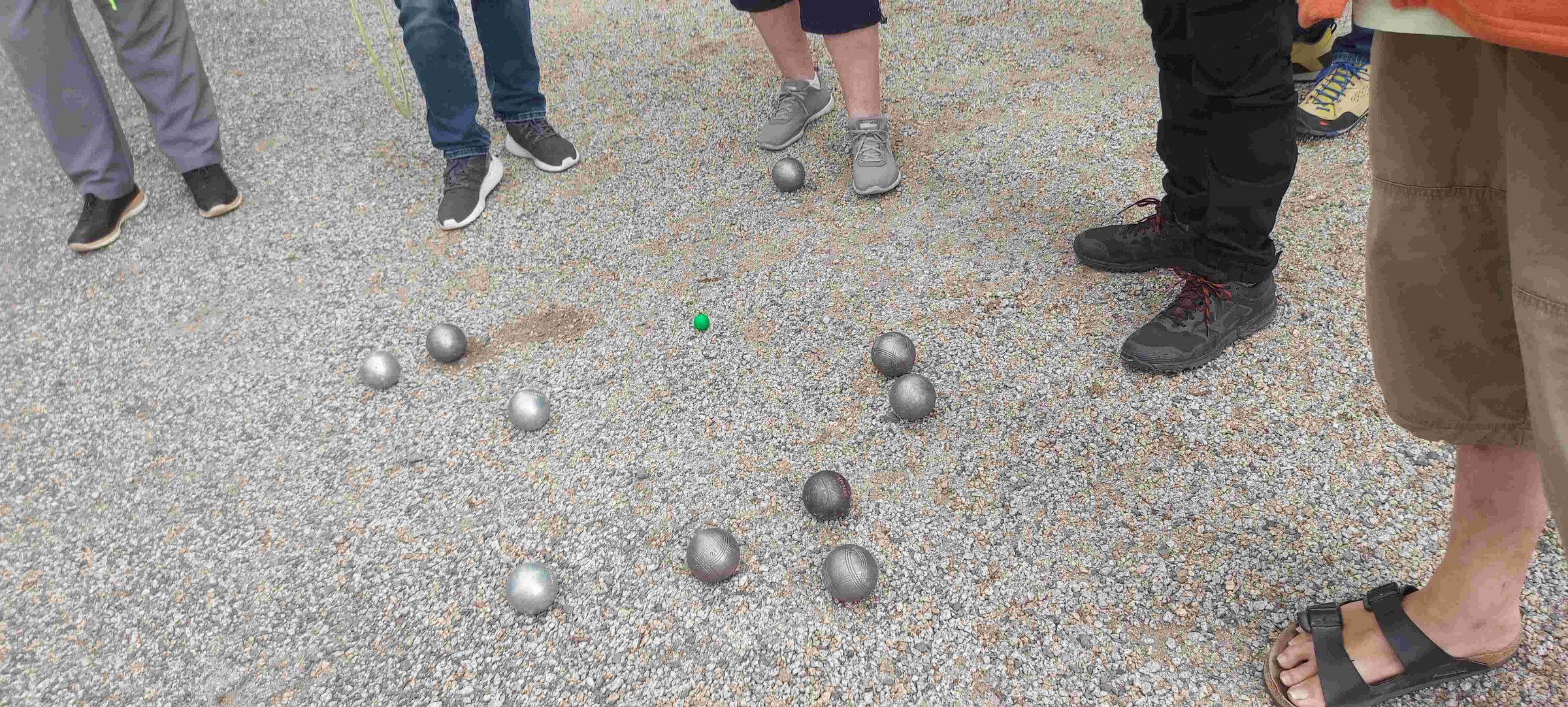 Boulekugeln am Boden, Beine der umstehenden sind zu sehen