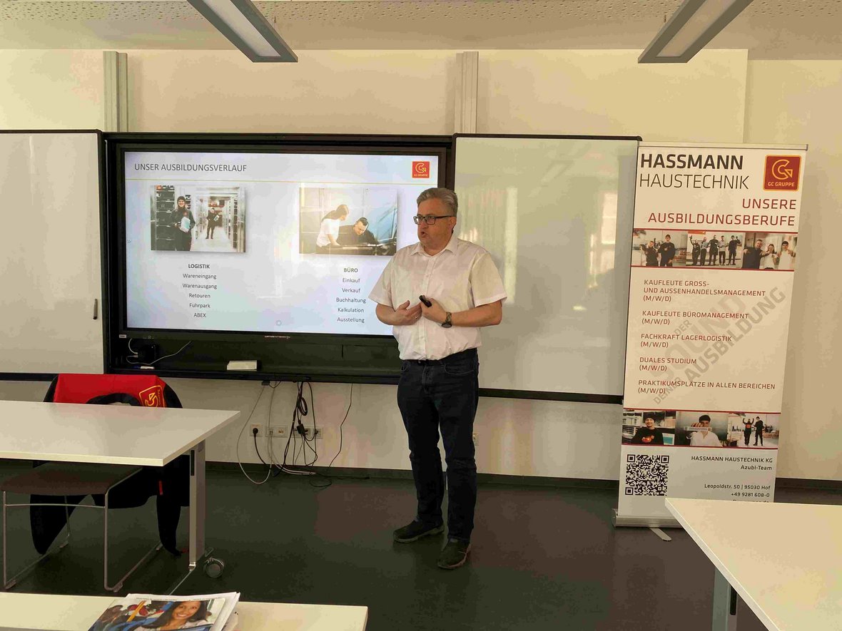 Referent steht vor digitaler Tafel