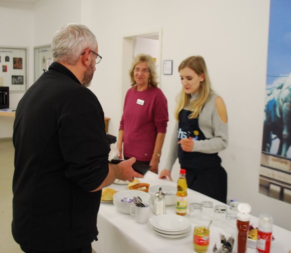 zwei Damen stehen hinter einem Tisch und verkaufen Wiener zwei Damen stehen hinter einem Tisch und verkaufen Wiener