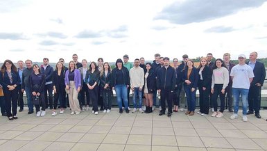 Gruppe Azubis stehen auf einer Dachterrasse