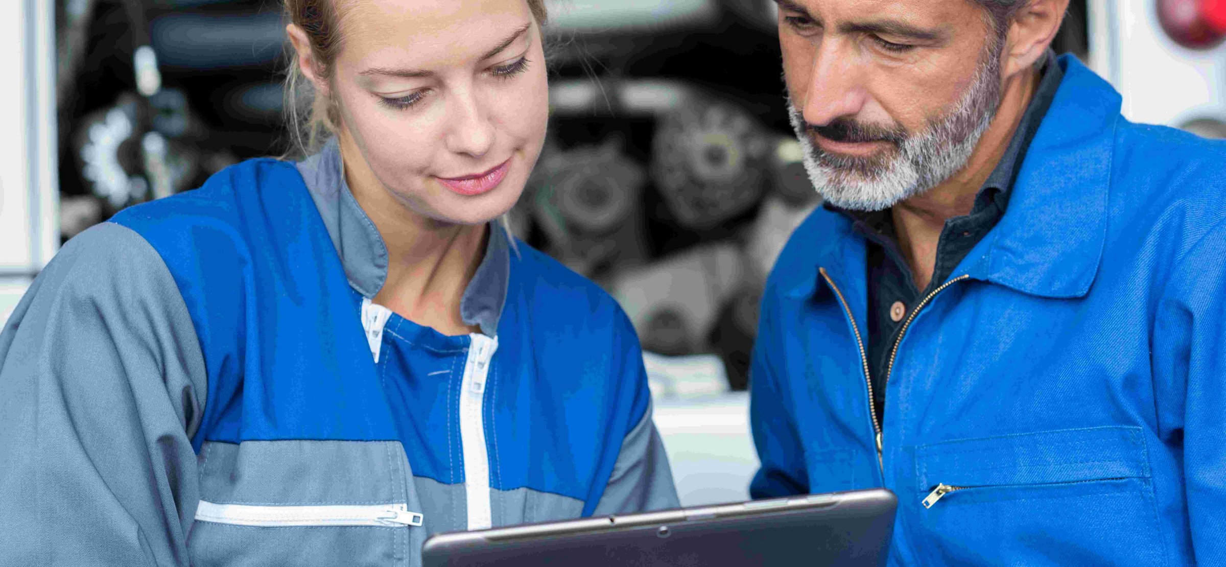 Zwei Handwerker schauen aufs Tablet