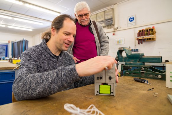 zwei Herren sind in einer Werkstatt und reparieren etwas zwei Herren sind in einer Werkstatt und reparieren etwas