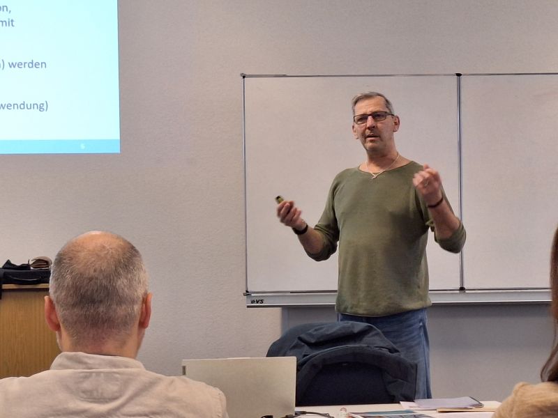 Jörg Reis steht vor Klasse, einige Köpfe von hinten