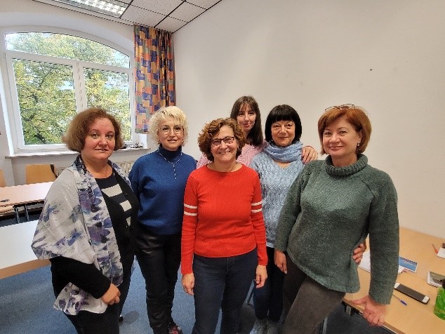 Sechs Frauen stehen zusammen und schauen lächelnd in Kamera