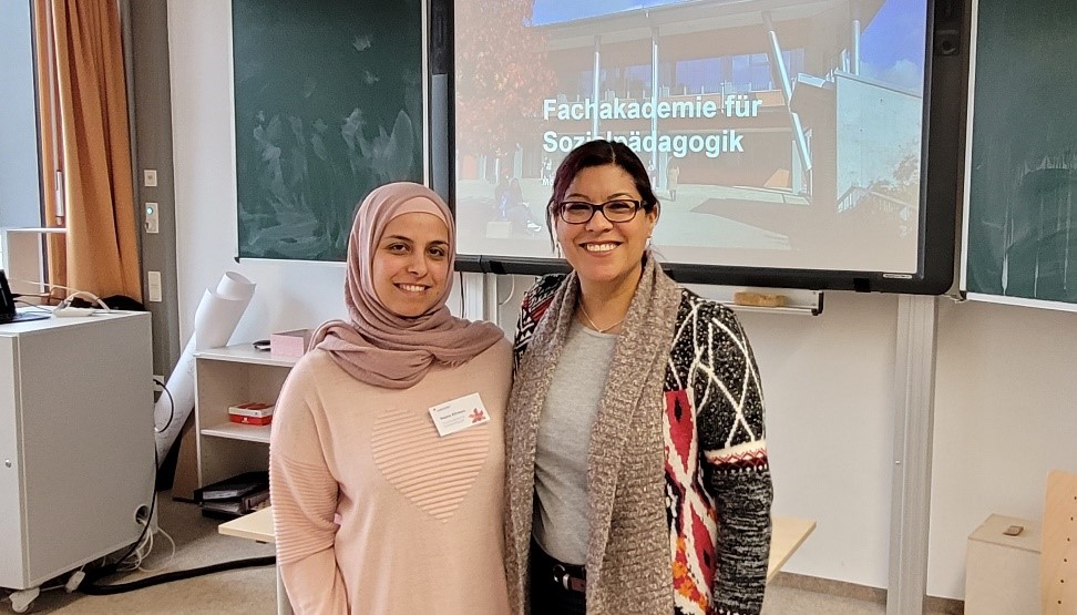 Lehrerin und VHS-Mitarbeiterin schauen lächelnd in Kamera