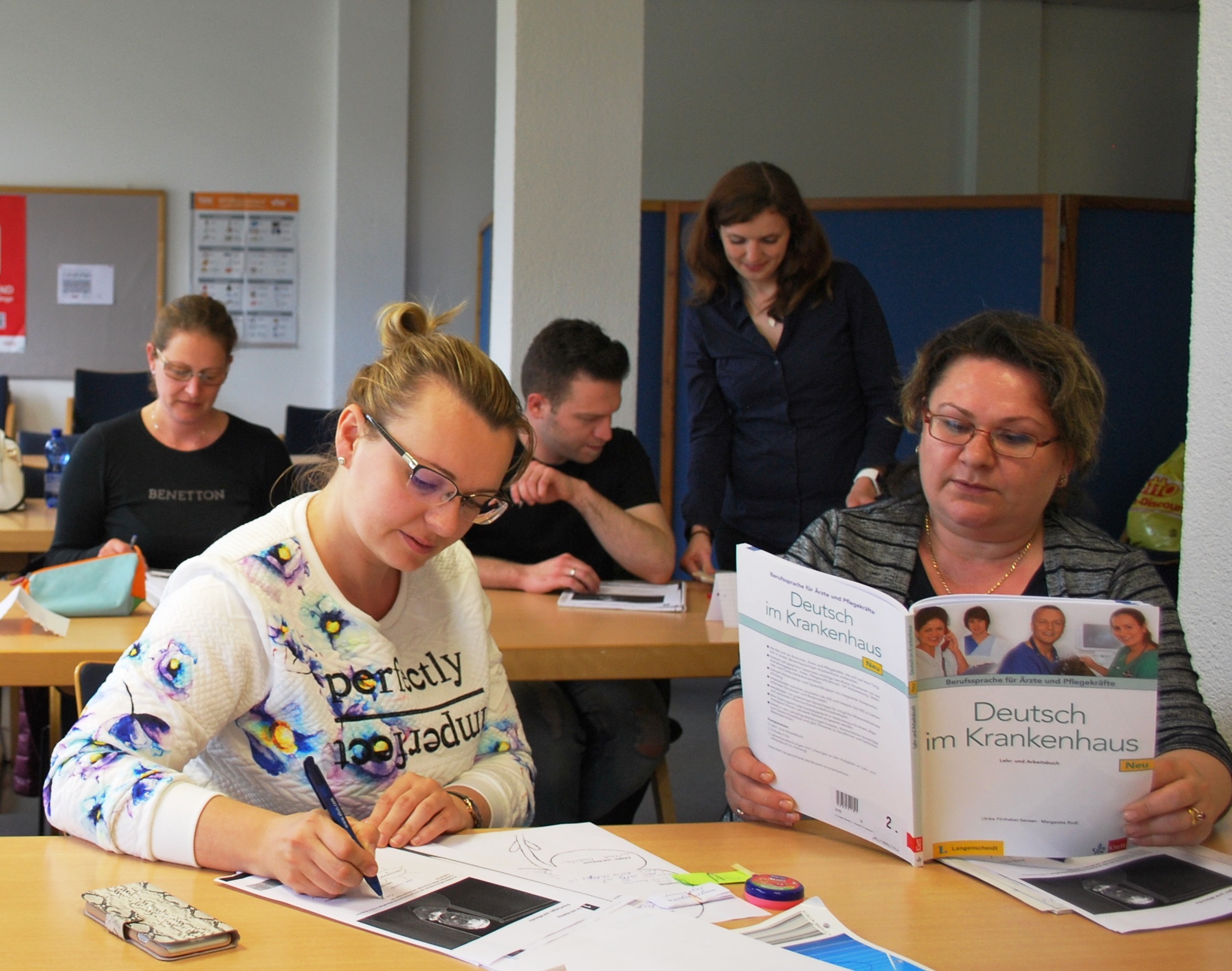 Hier sieht man zwei Teilnehmer*innen die an einen Berufsbezogenen Deutsch Sprachkurs teilnehmen.